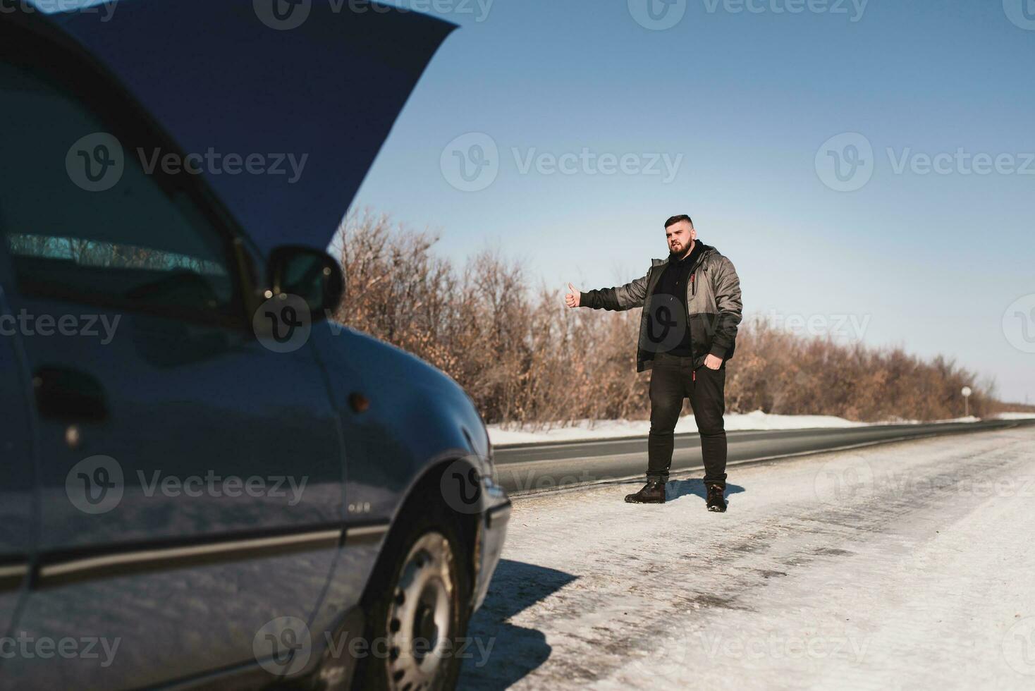guy catches a car standing by the road photo
