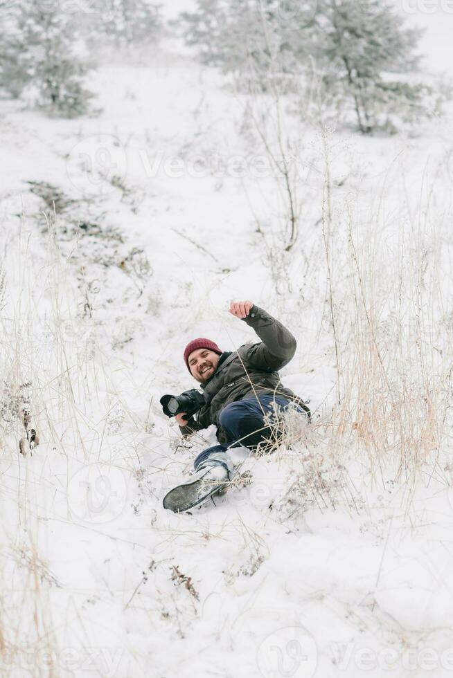 cheerful traveler photographer slipped and fell on snow photo