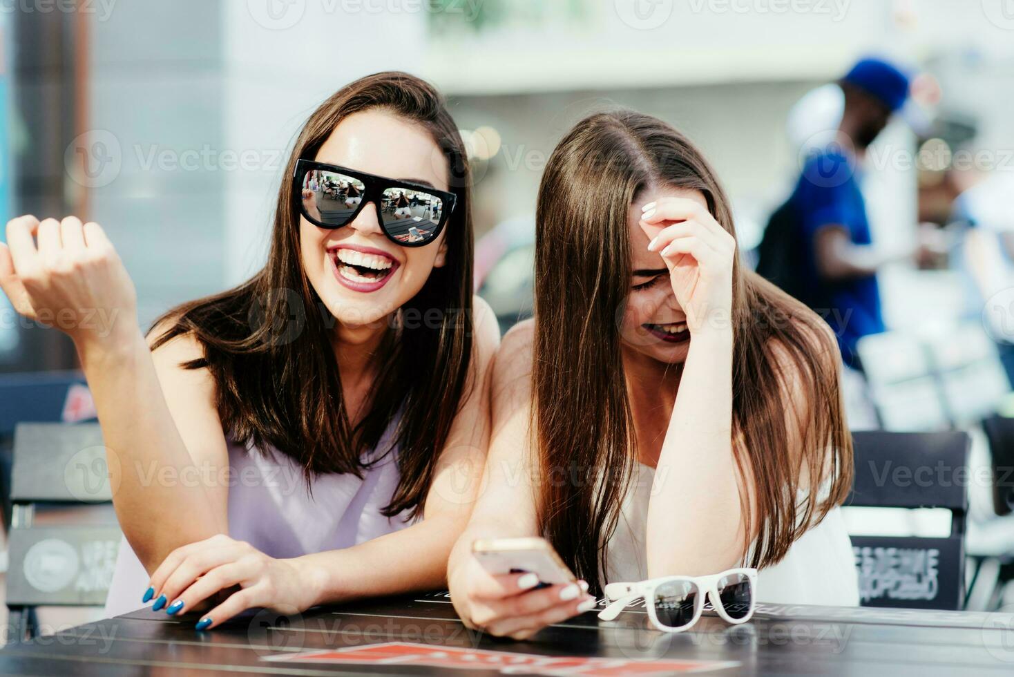 muchachas tener divertido con un teléfono en café foto