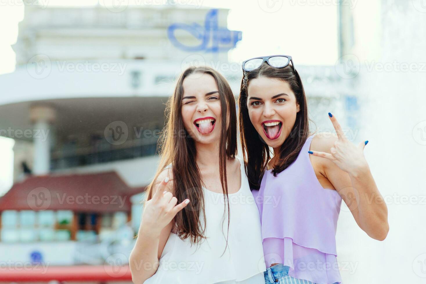 dos hermosa muchachas teniendo divertido en el calle foto