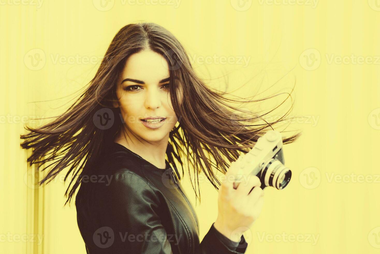 Beautiful girl posing with an old camera photo