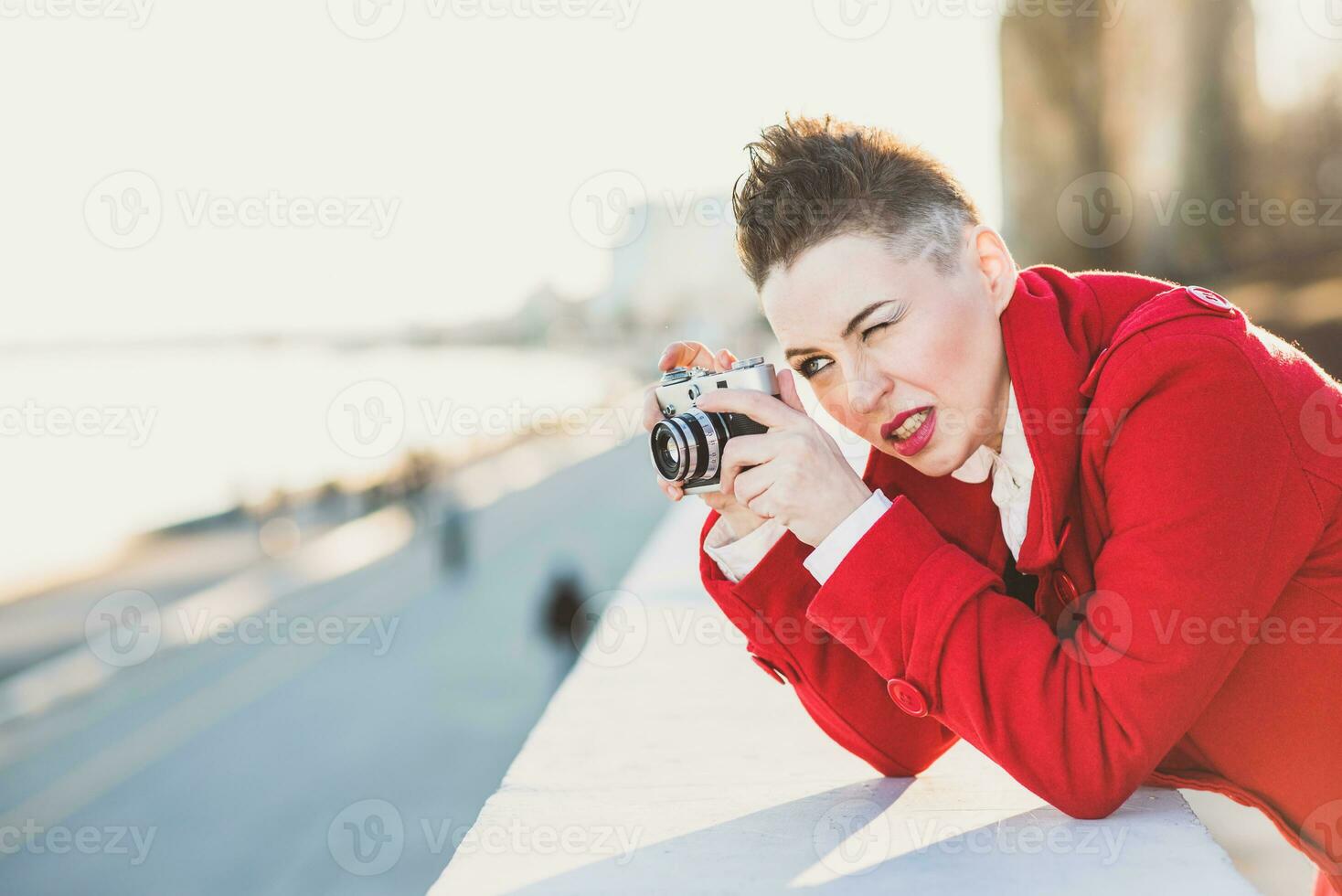 Girl taking pictures on the waterfront at sunset photo