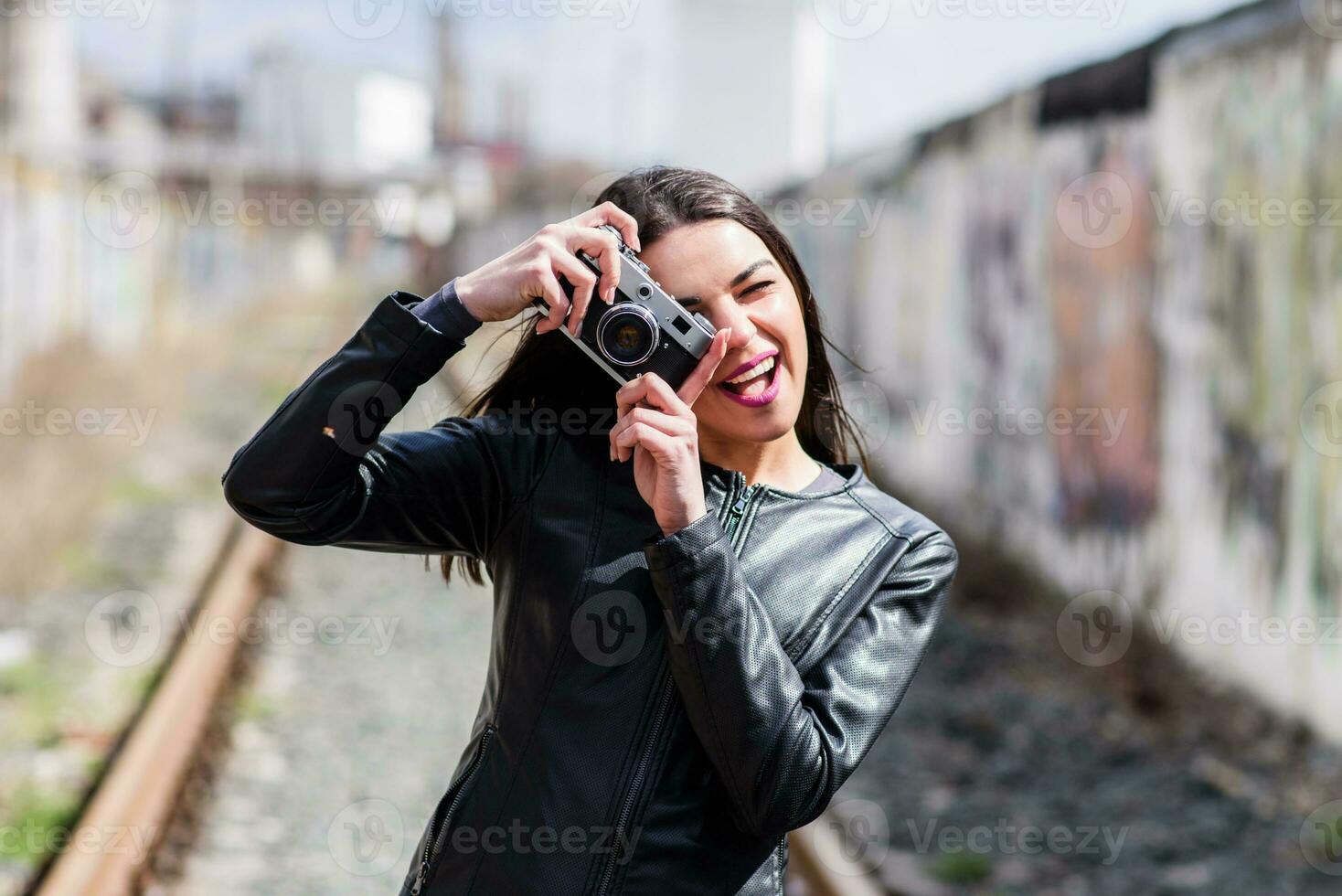 atractivo niña toma imágenes con un antiguo cámara foto