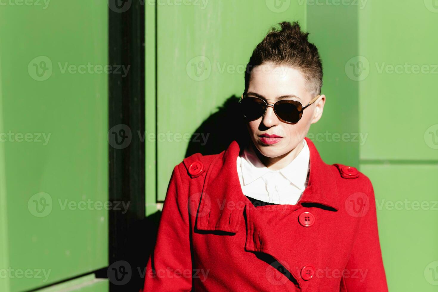 Girl in glasses posing on green background photo