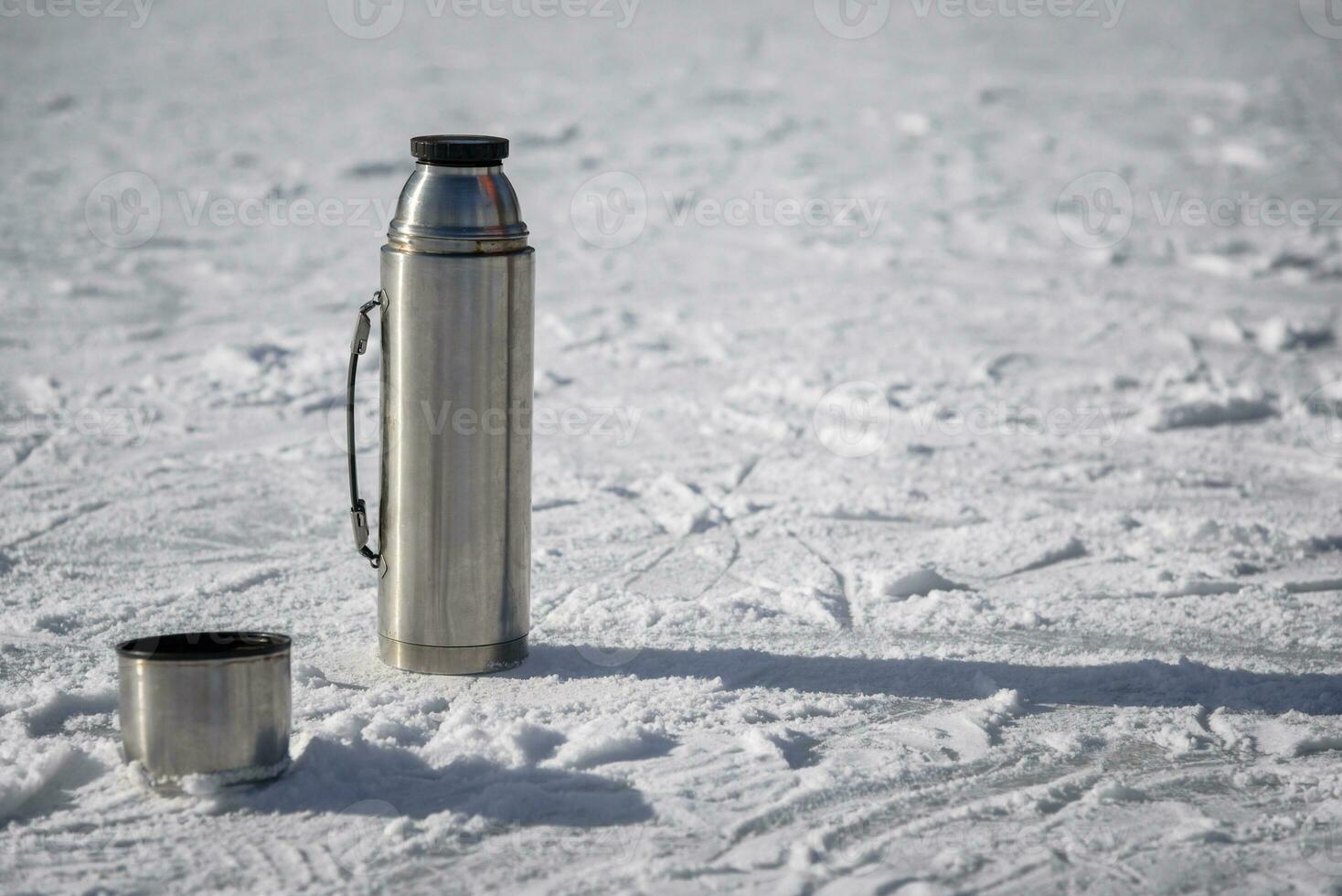 el termo soportes en hielo con un taza de caliente té foto