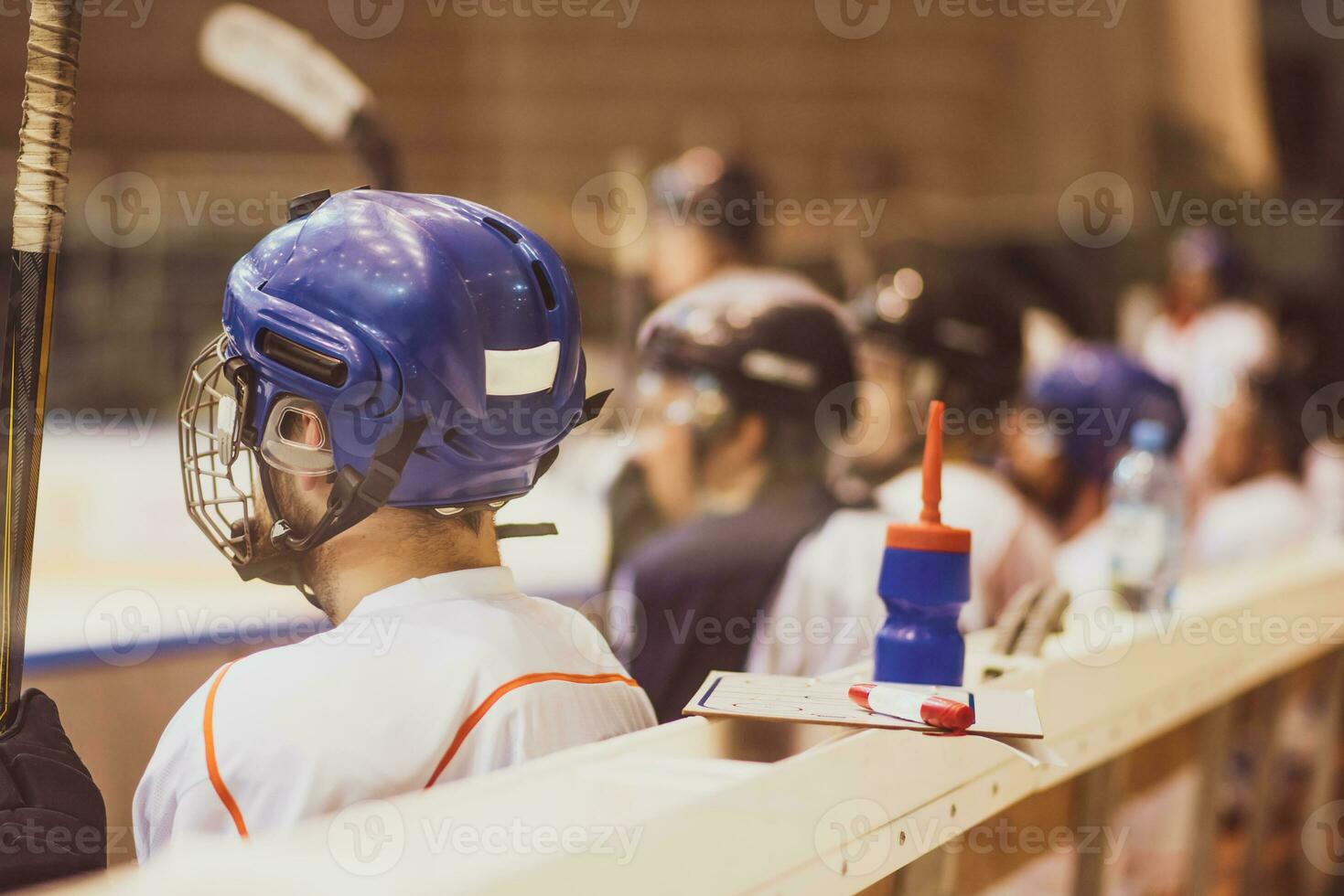 hockey players sit on the bench during the match photo