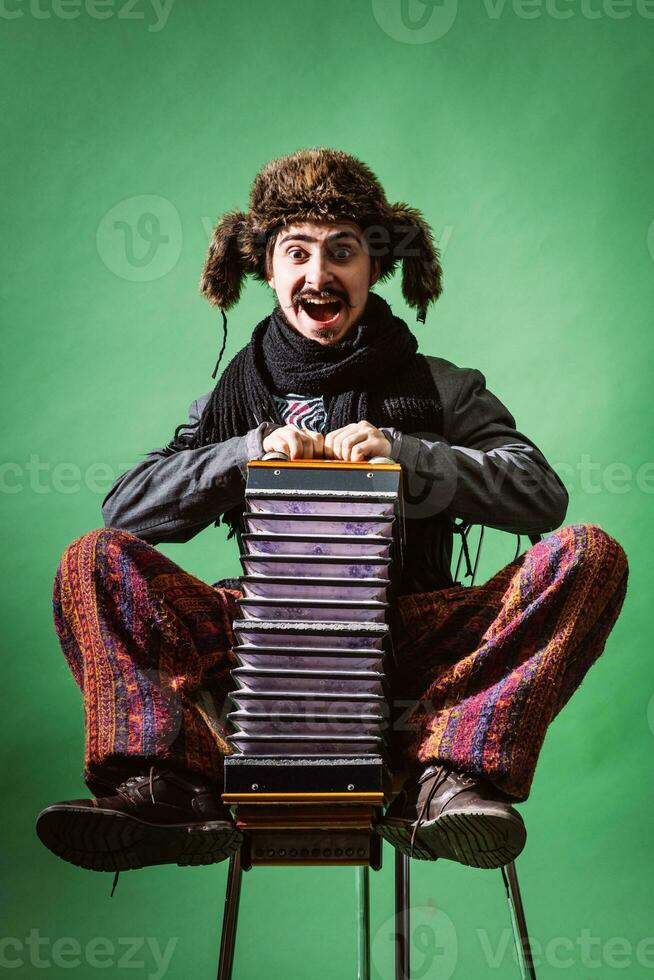 un muy positivo hombre con un acordeón posando en el estudio foto