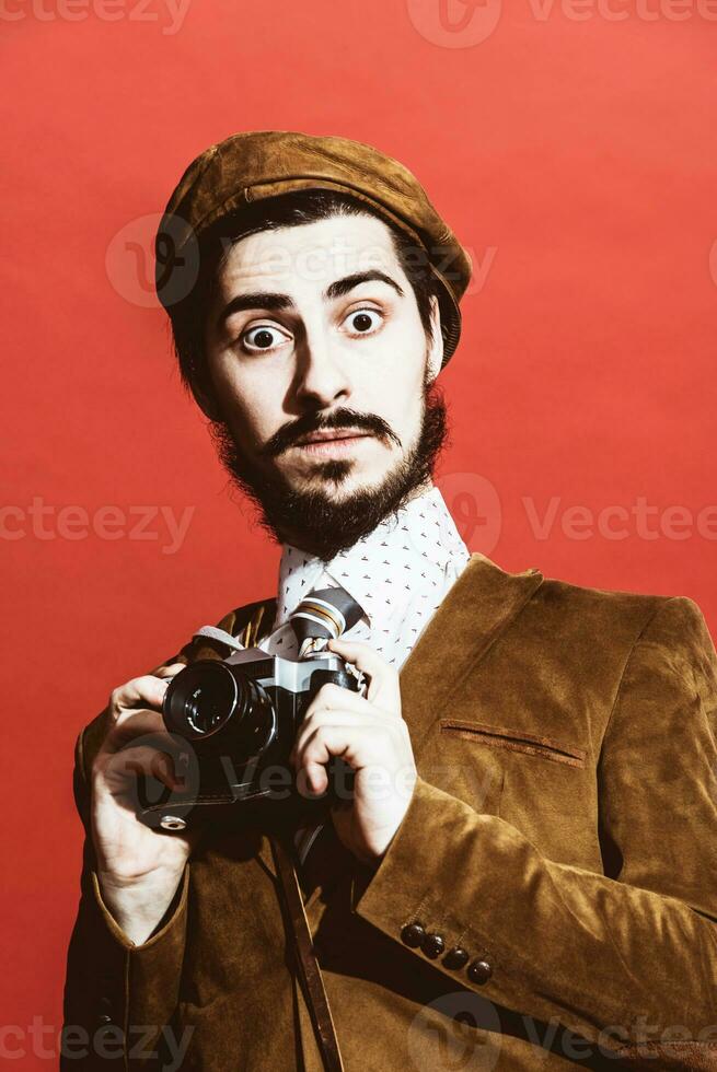 very positive photographer posing in studio with film camera photo