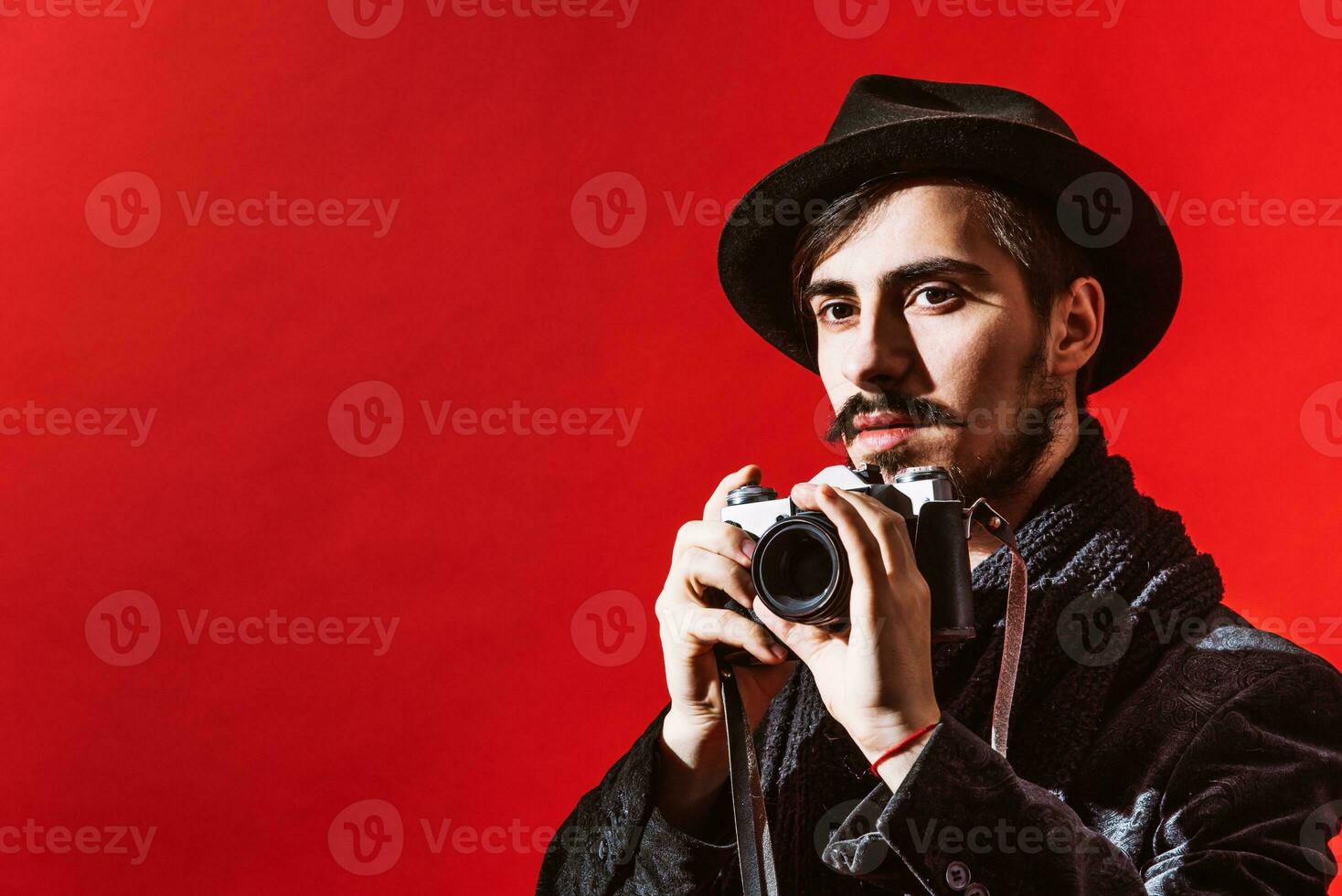 creative photographer posing in studio with camera photo