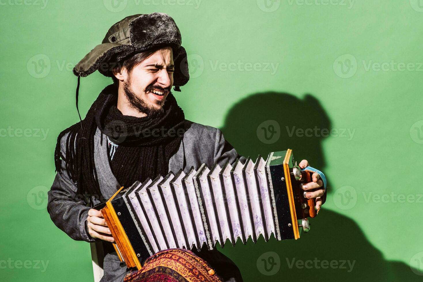 a very positive man with an accordion posing in the studio photo