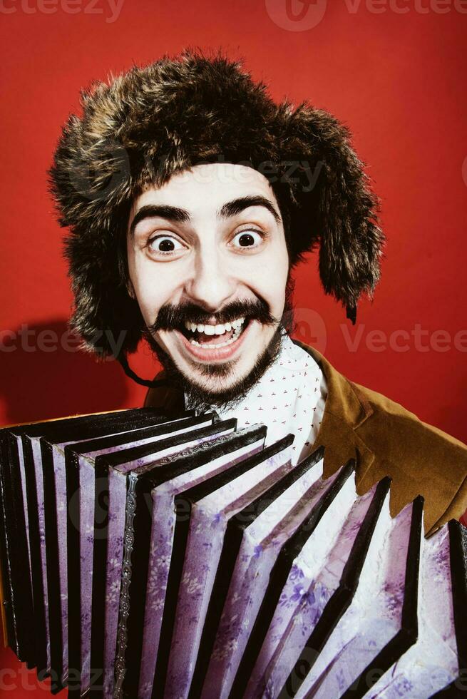 un muy positivo hombre con un acordeón posando en el estudio foto