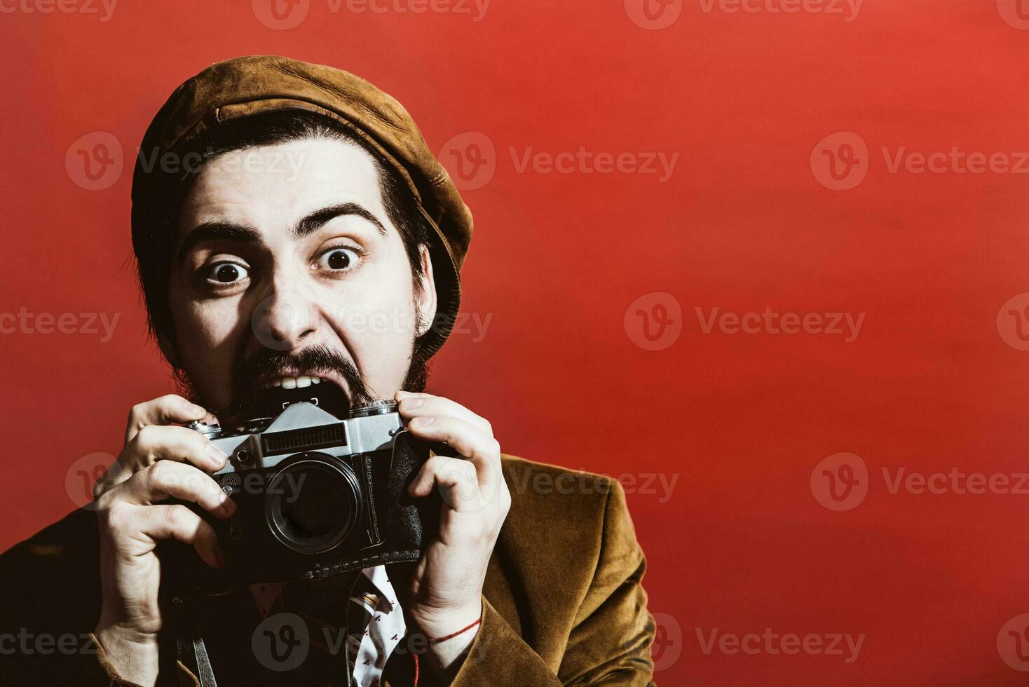 very positive photographer posing in studio with film camera photo