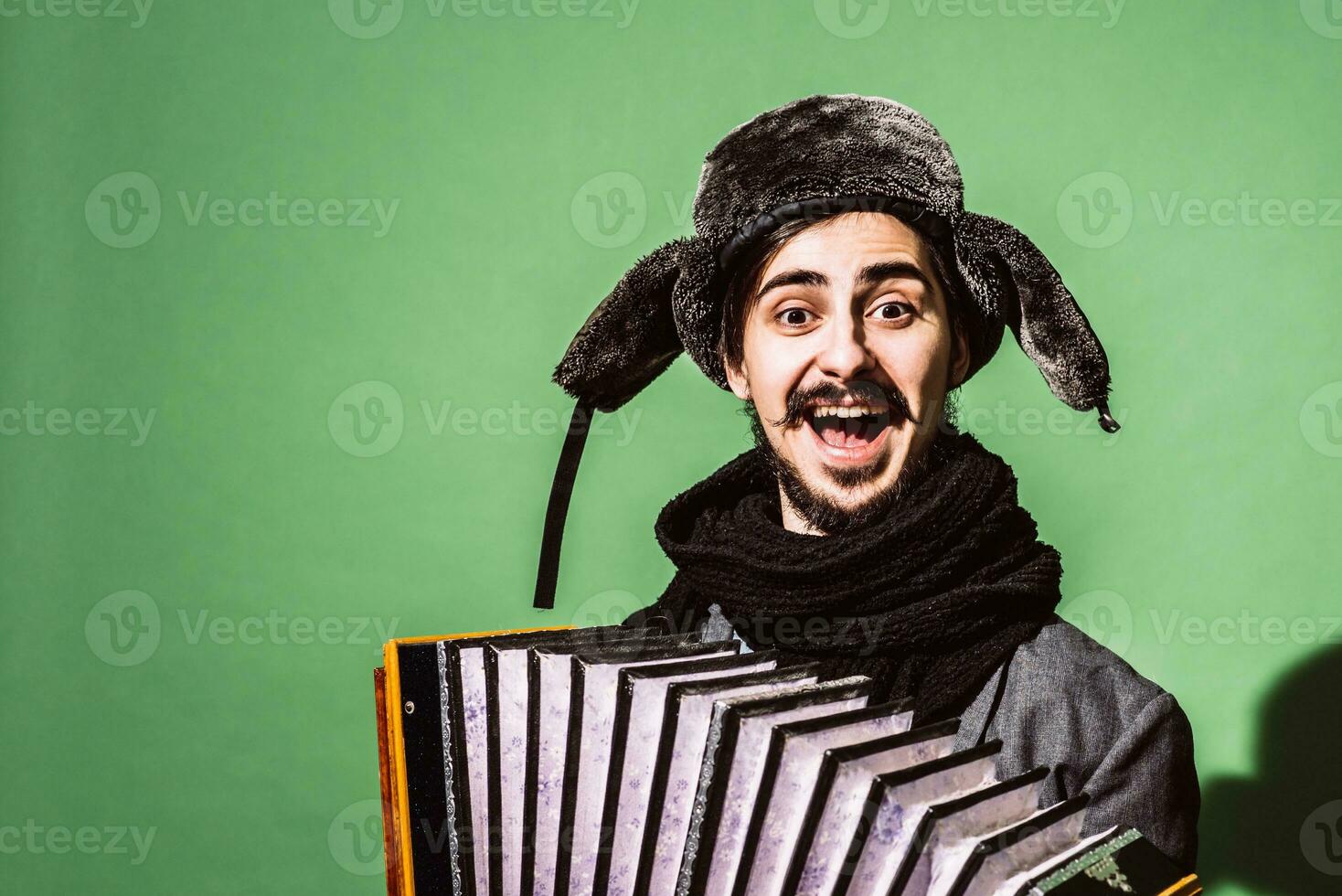 un muy positivo hombre con un acordeón posando en el estudio foto