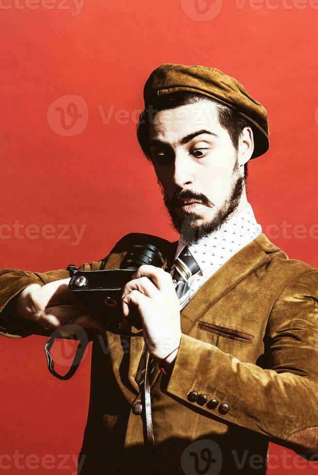 very positive photographer posing in studio with film camera photo