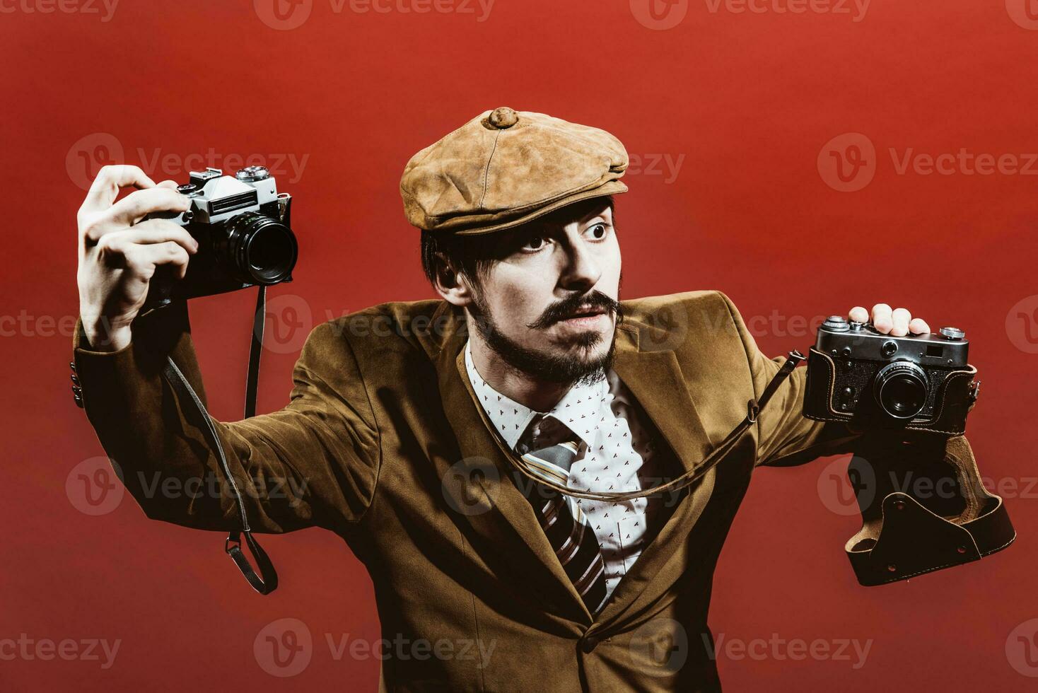 very positive photographer posing in studio with cameras photo