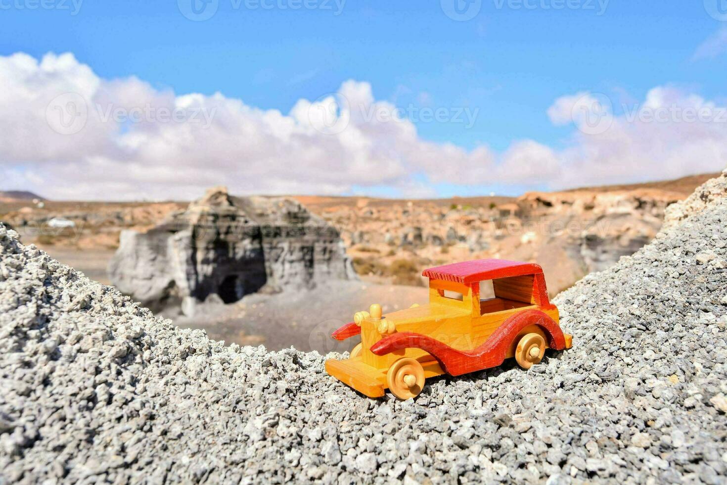 a toy car sits on top of a mountain photo