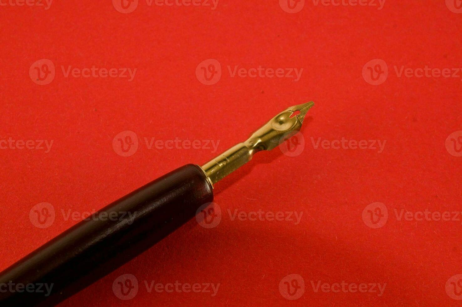 a fountain pen laying on top of a red surface photo