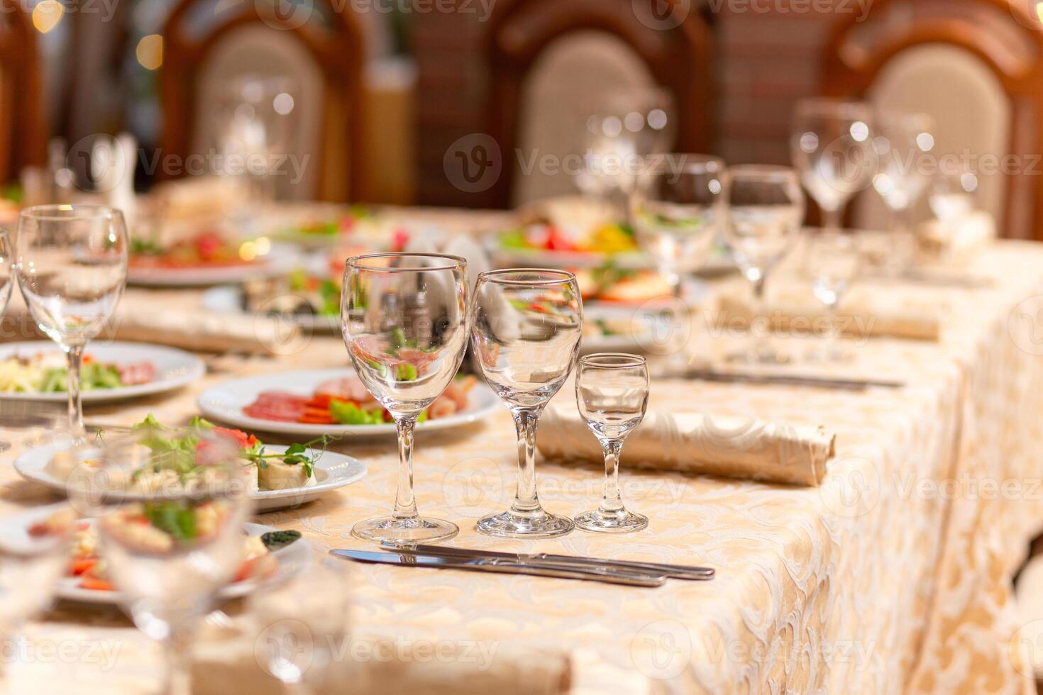 servido festivo mesa con aperitivos, anteojos, anteojos, cuchillería y servilletas para un banquete foto