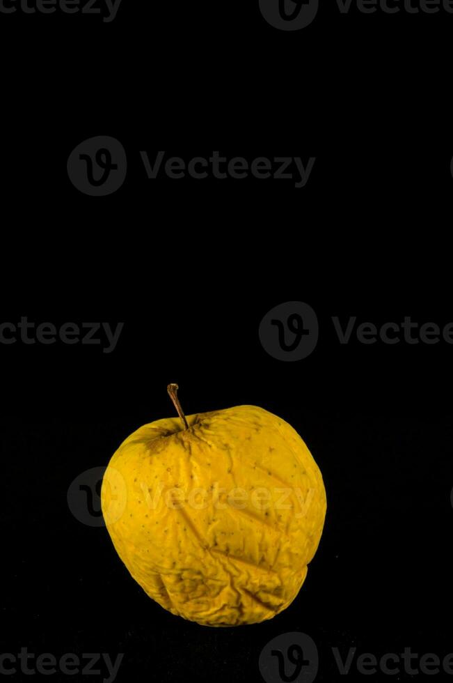 a yellow apple on a black background photo