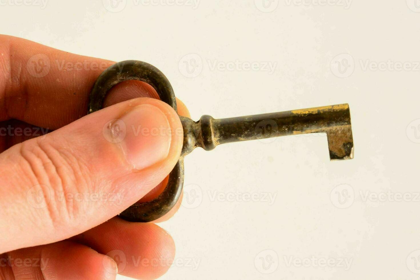 a person holding an old key in their hand photo