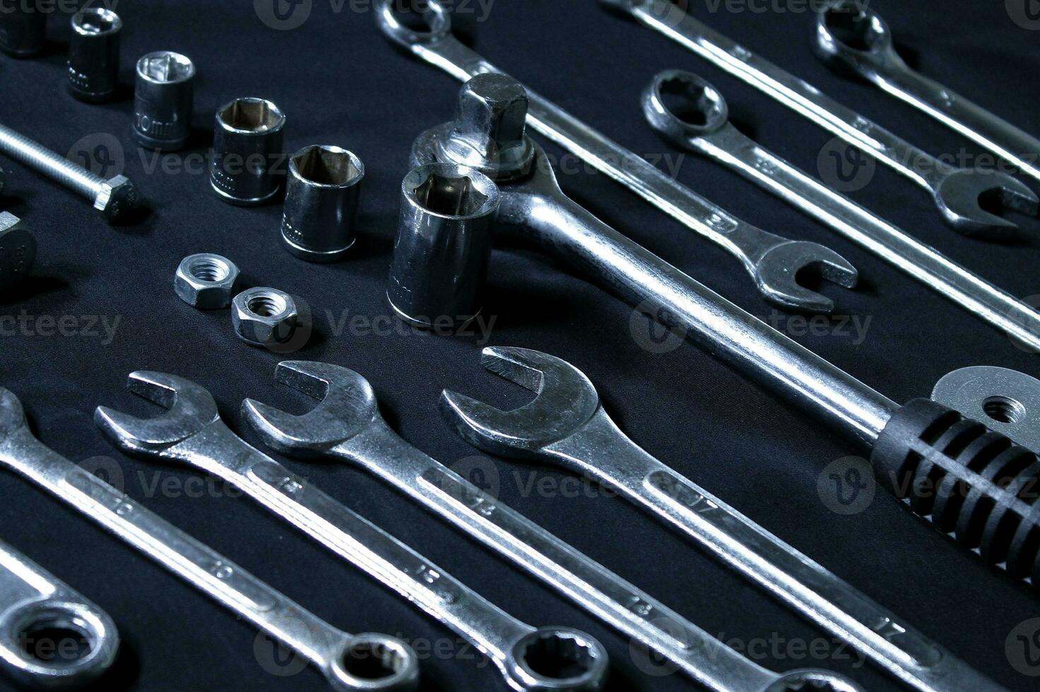 Steel Shiny Set Of Spanners, Sockets, Quick Release Ratchet And Hardware Items Laid Out In Order On Black Surface photo