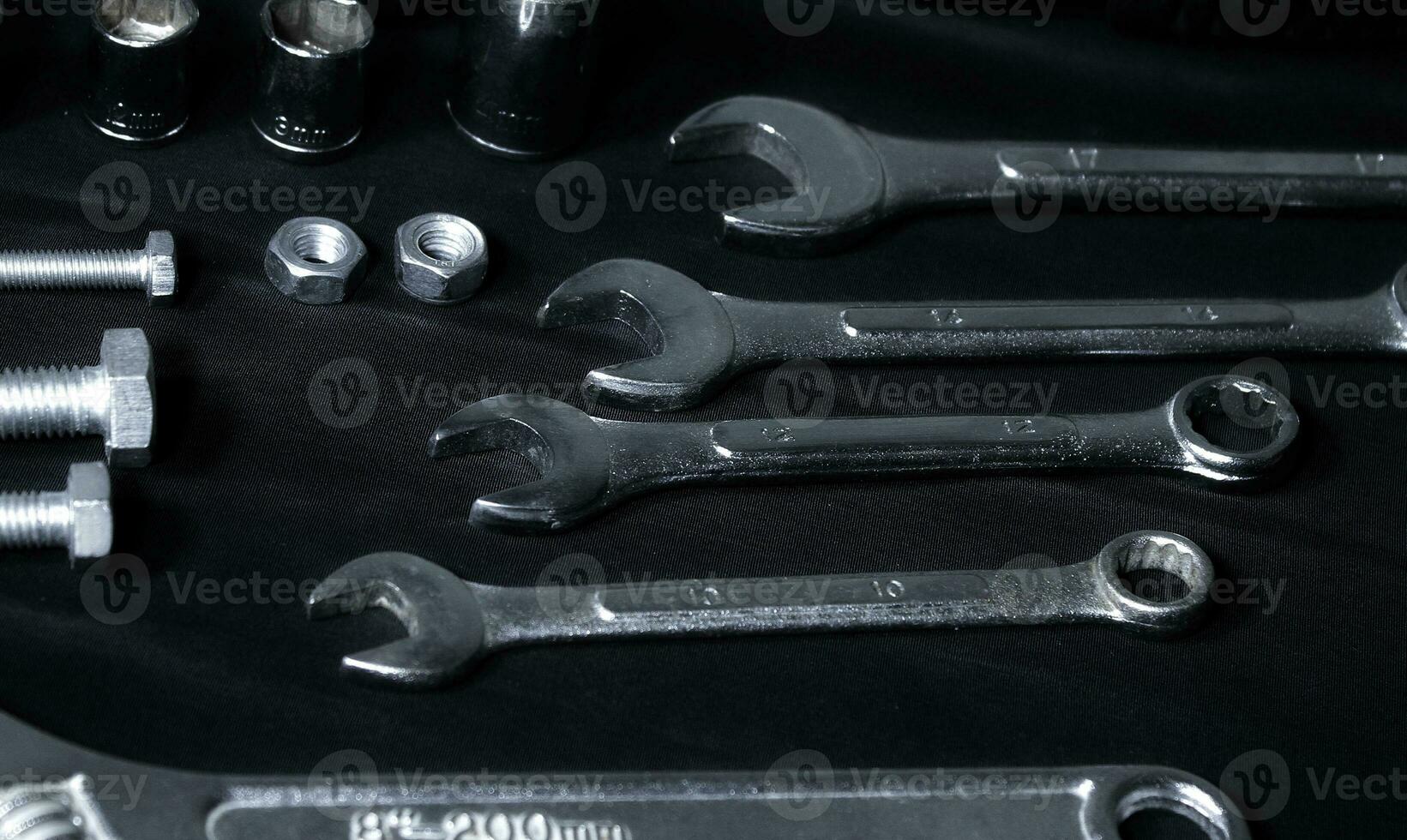 Open End Wrenches And Hardware Items Laid Out On Black Fabric photo