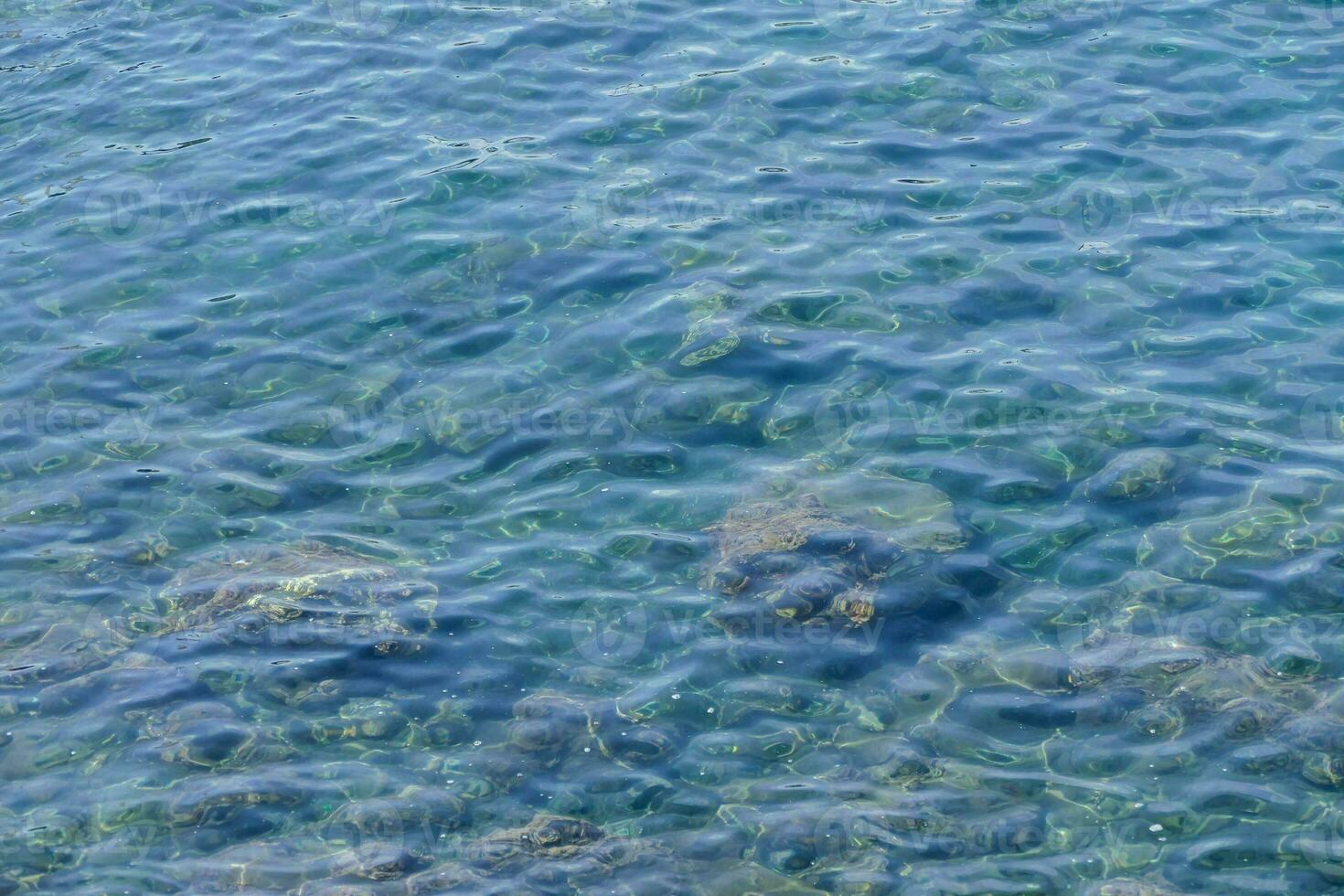 the water is clear and blue with lots of rocks photo