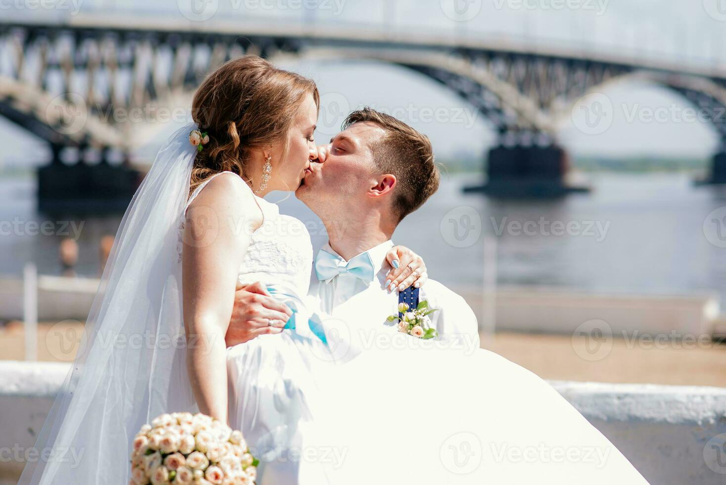 the bride and groom are photographed on the background of the bridge photo