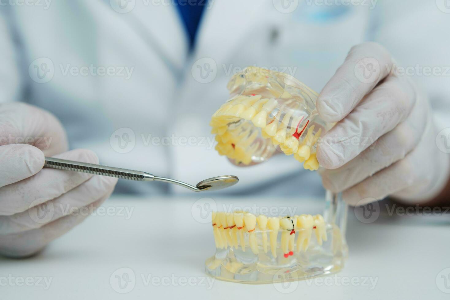 médico ortodoncista muestra el instrumento en caries en el dientes foto