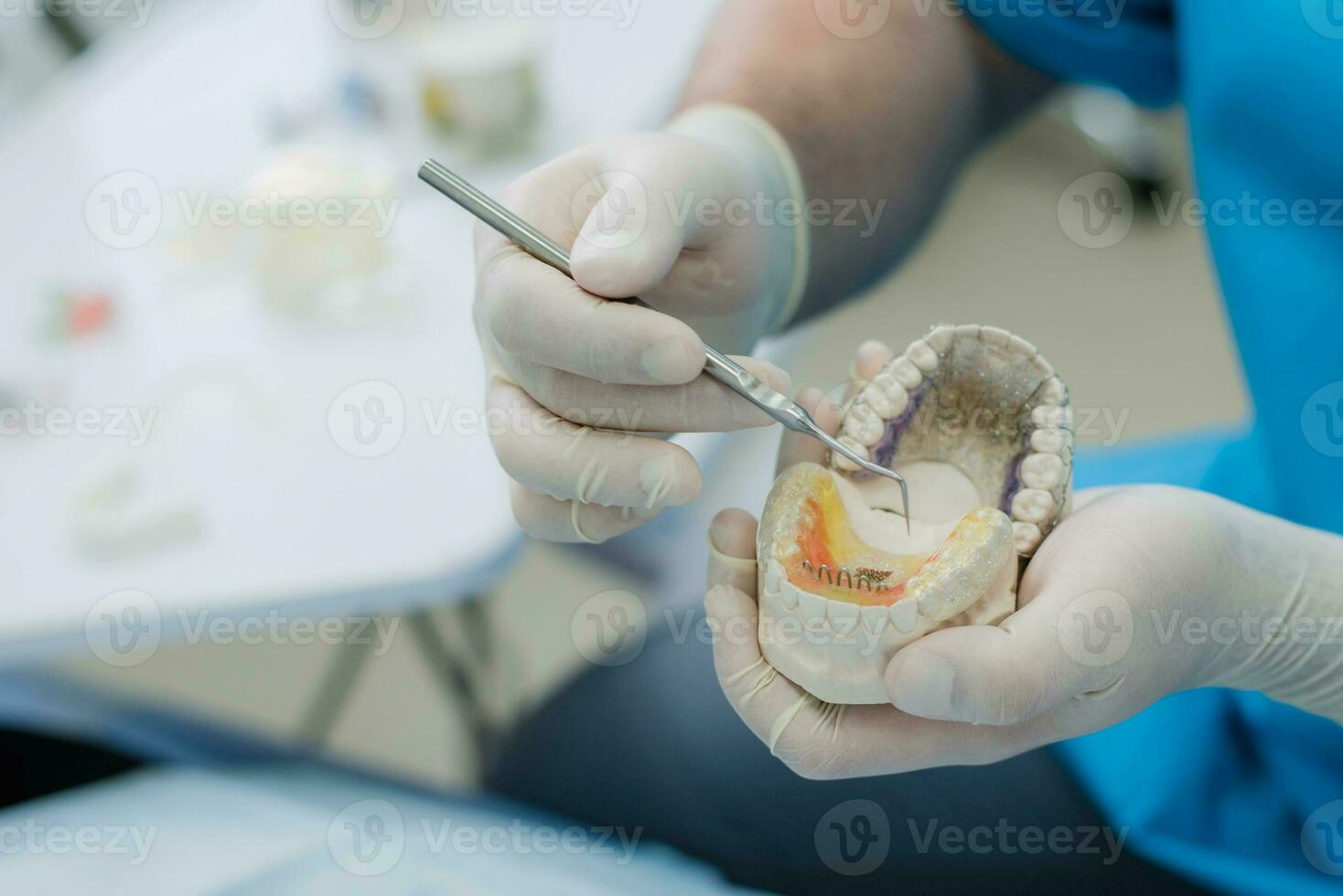 médico ortodoncista presentado cómo el plato trabajos a aplanar dientes en el mandíbulas foto