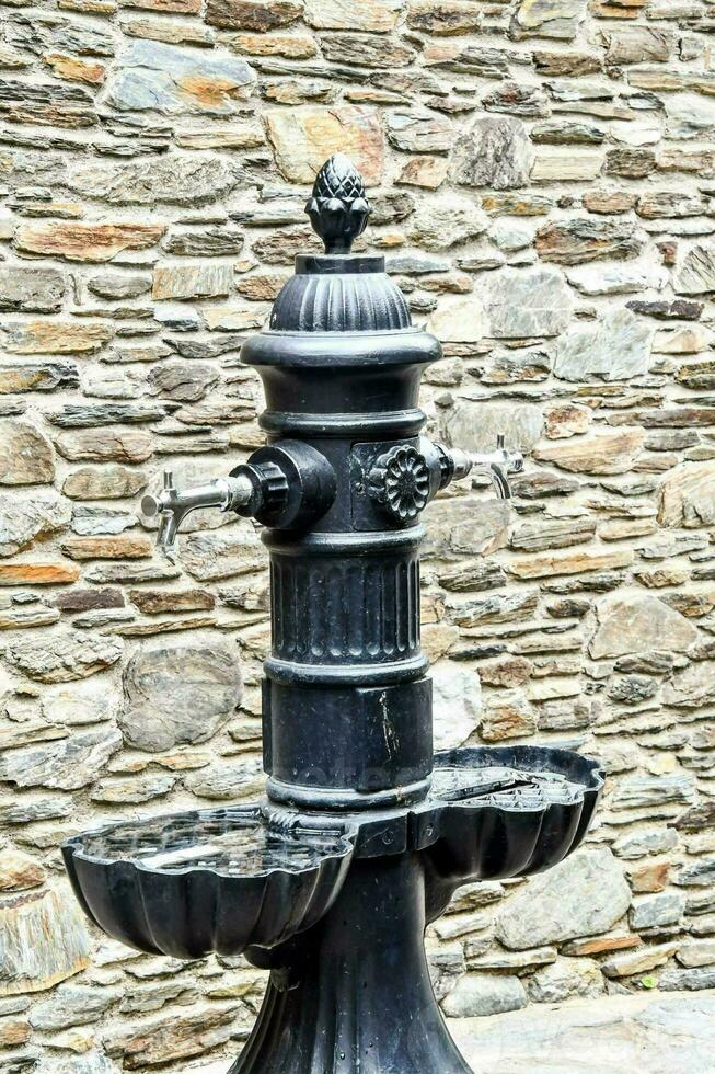 a black water fountain with two water bowls on it photo