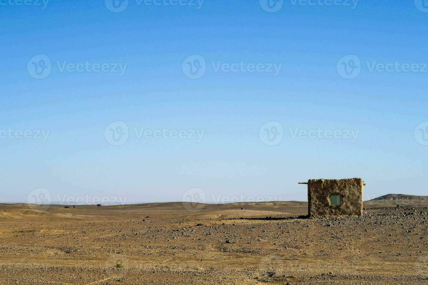 a small hut in the desert with a blue sky photo