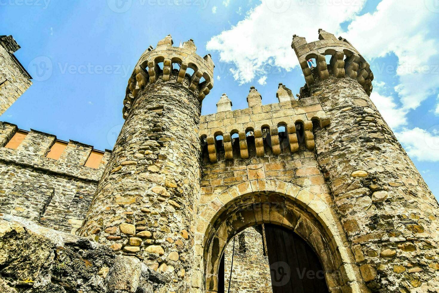 the entrance to a castle with stone walls and arched windows photo