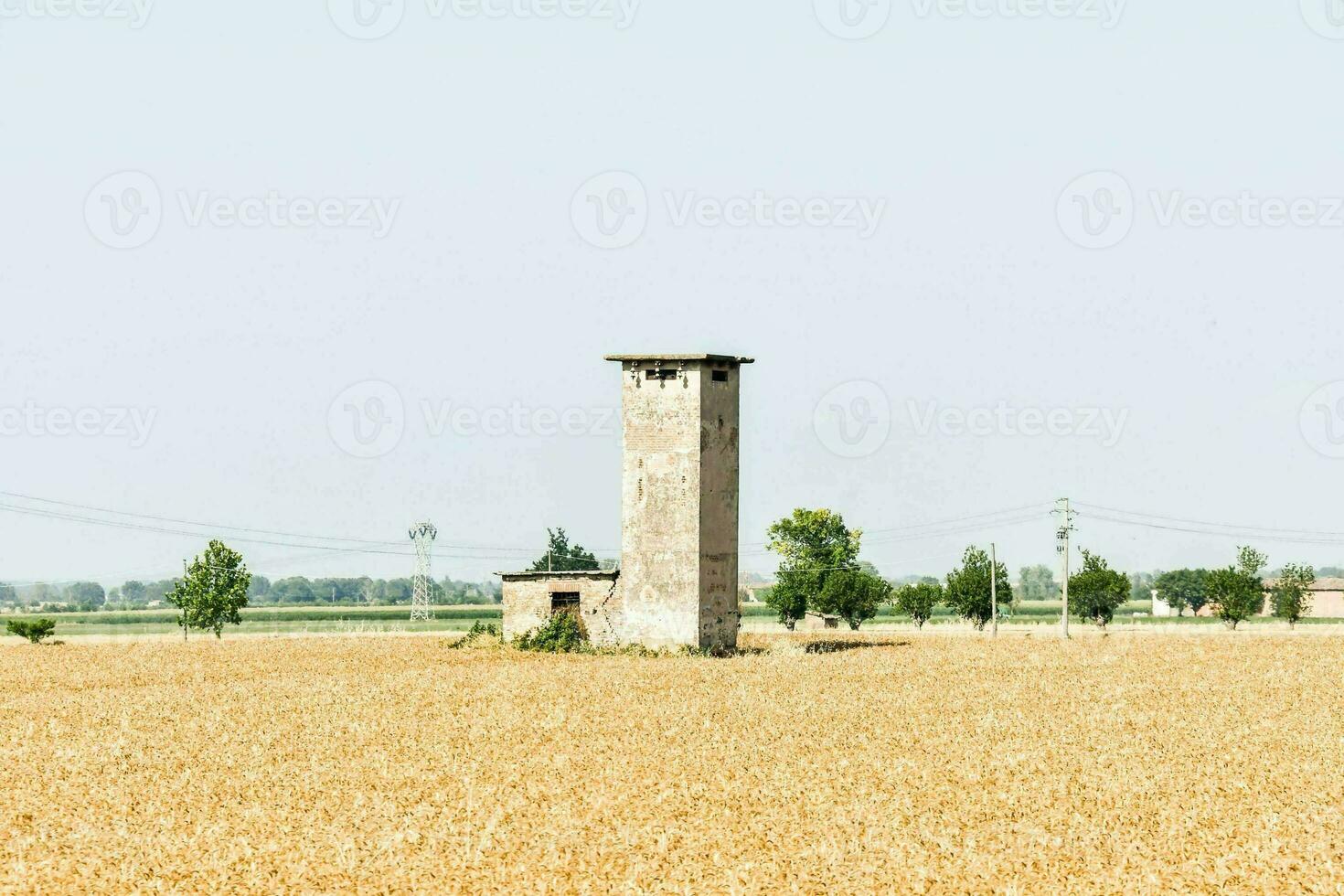 an old tower in a field of wheat photo