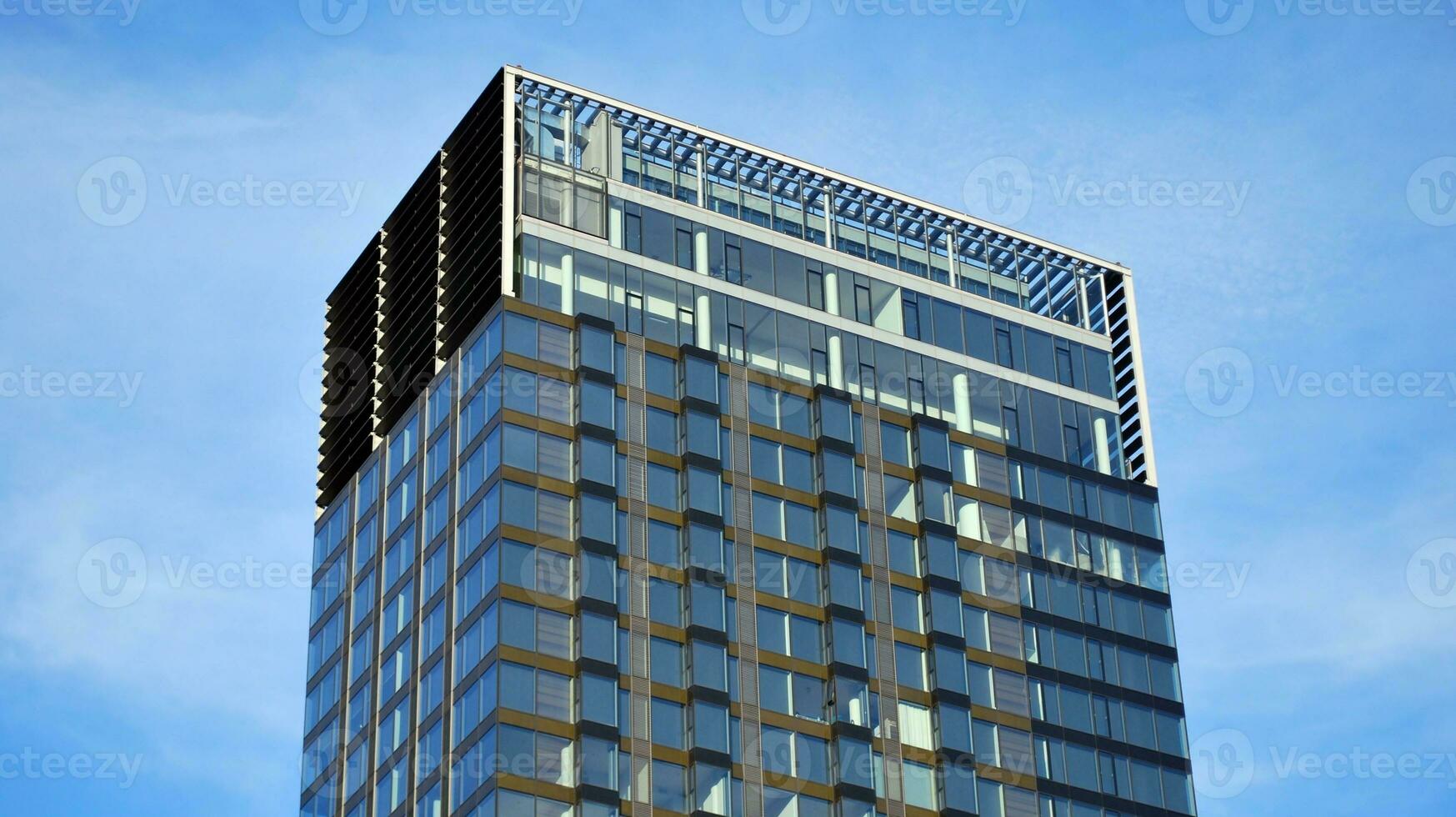 Structural glass wall reflecting blue sky. Abstract modern architecture fragment photo