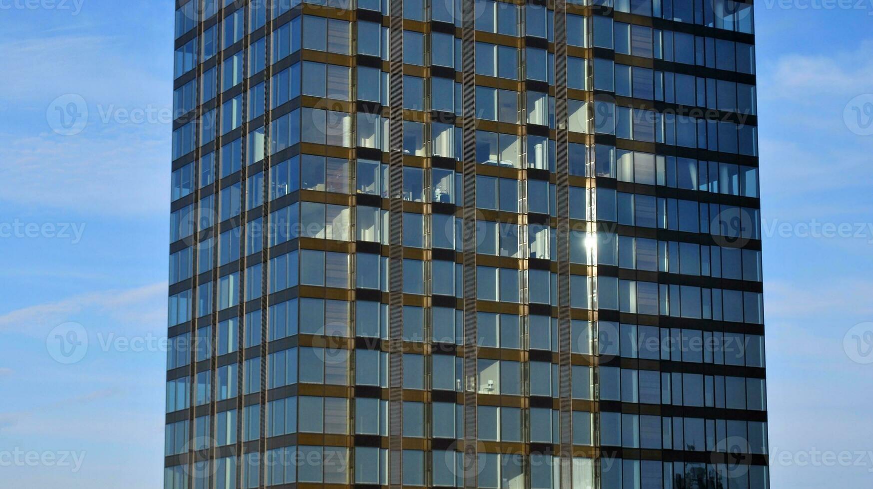 Structural glass wall reflecting blue sky. Abstract modern architecture fragment photo