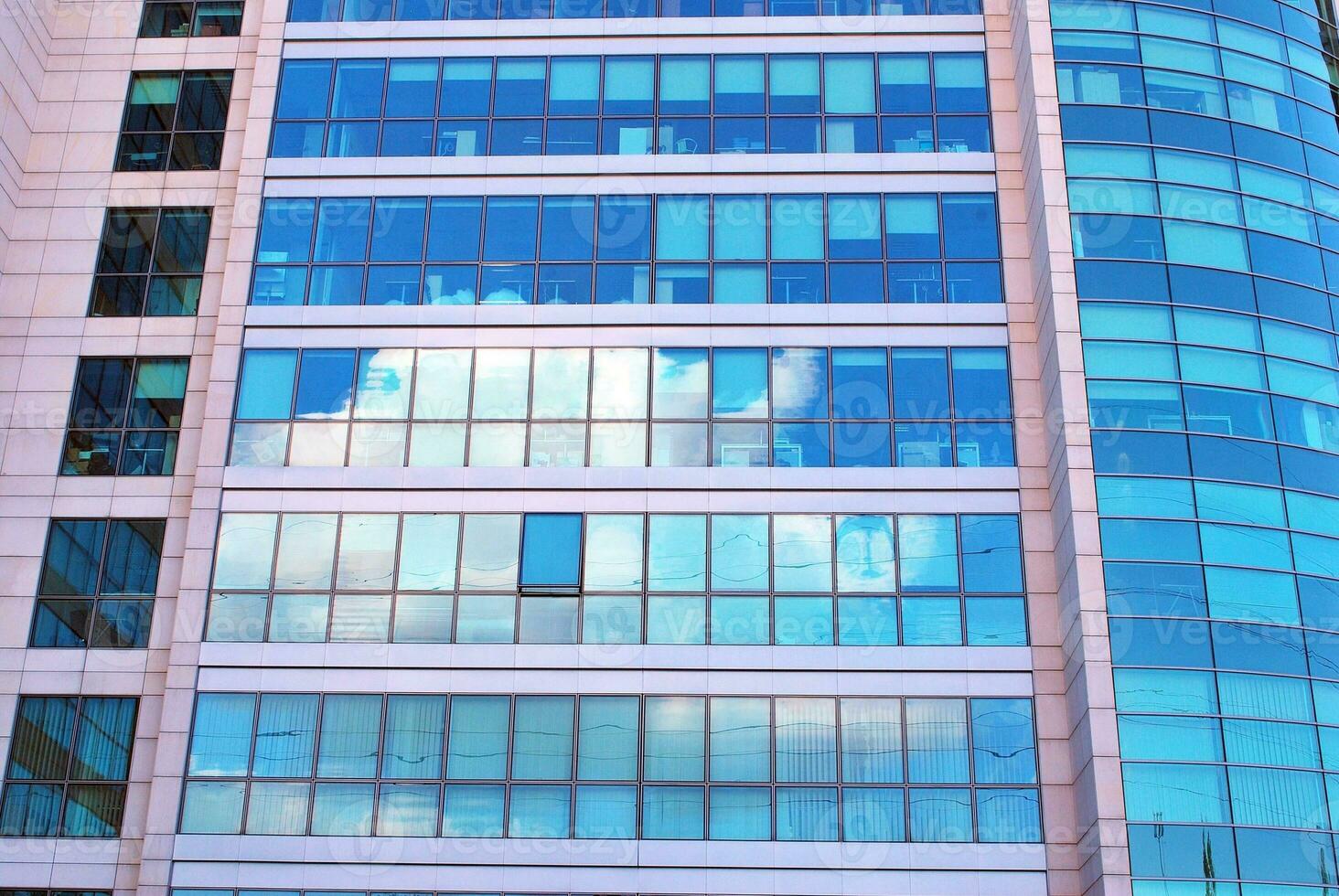 Structural glass wall reflecting blue sky. Abstract modern architecture fragment photo