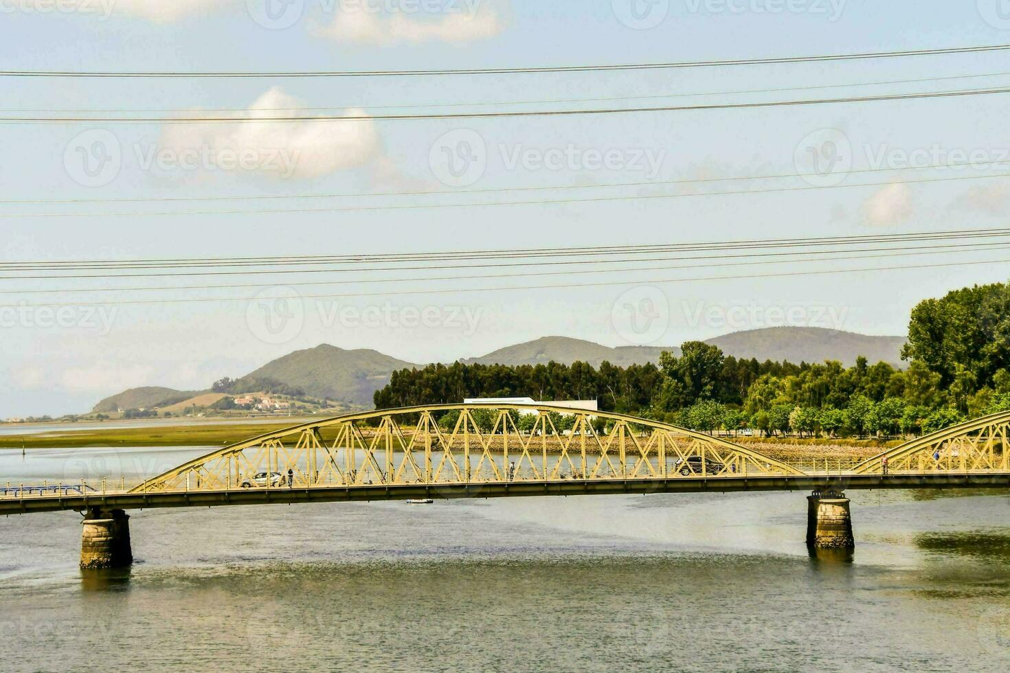 a bridge spanning the river with a mountain in the background photo