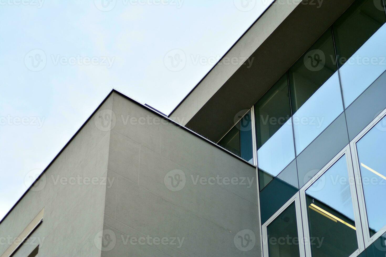 Structural glass wall reflecting blue sky. Abstract modern architecture fragment photo