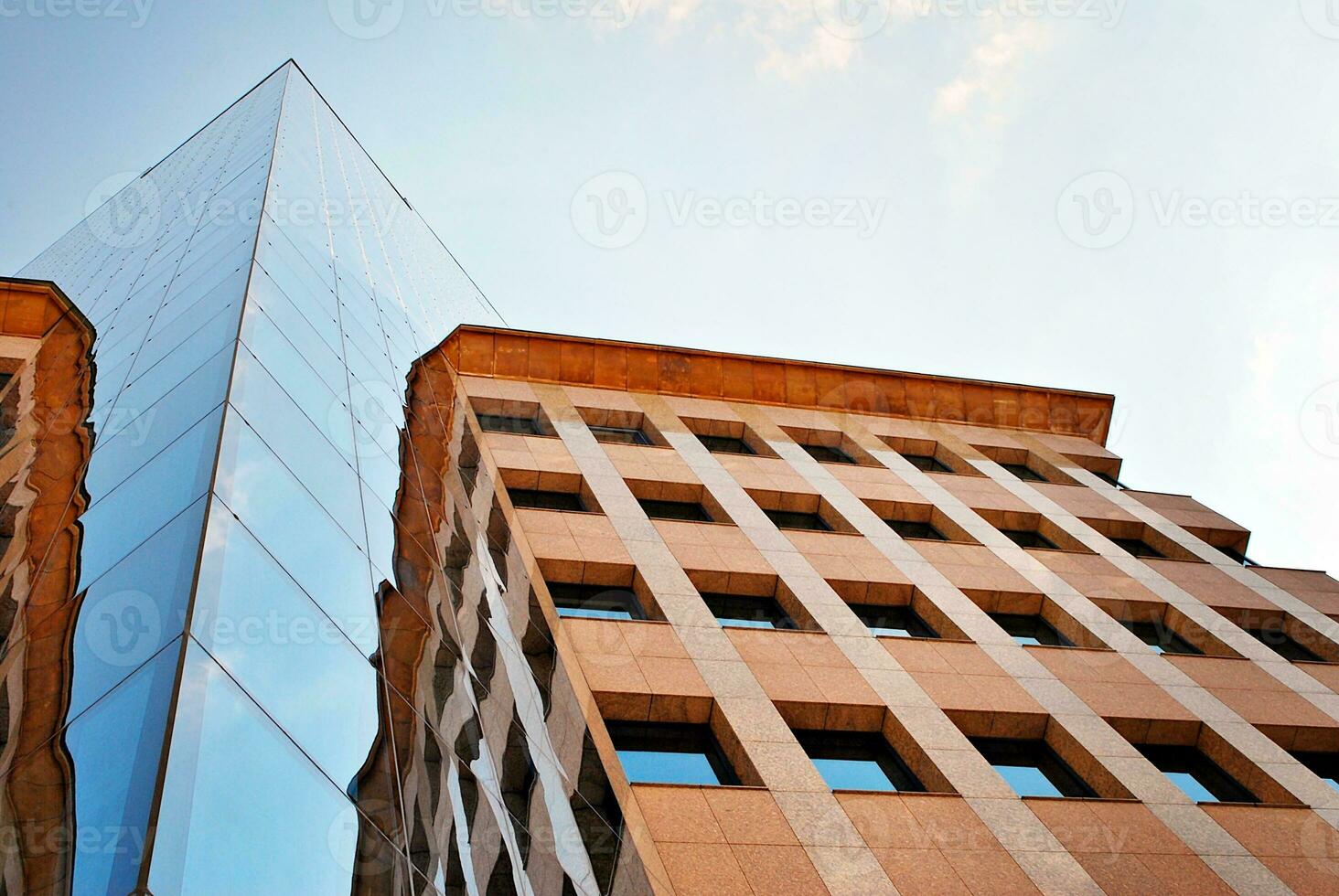 Structural glass wall reflecting blue sky. Abstract modern architecture fragment. photo