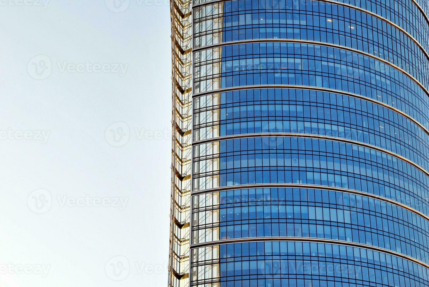 Structural glass wall reflecting blue sky. Abstract modern architecture fragment. photo