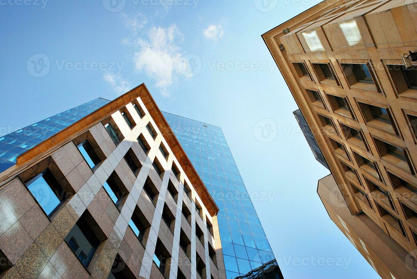 Structural glass wall reflecting blue sky. Abstract modern architecture fragment. photo