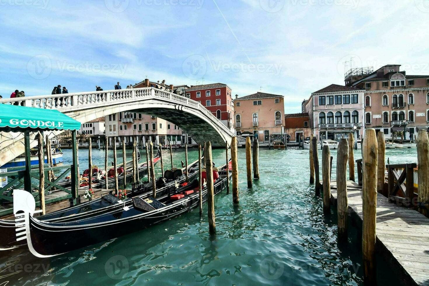 a gondola is docked in the water next to a bridge photo