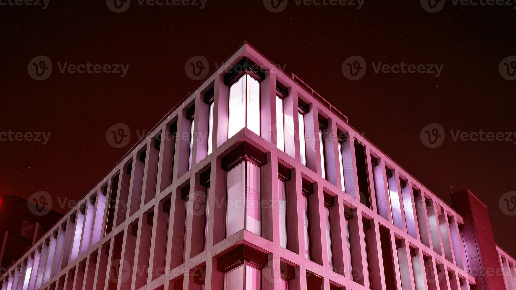 Night architecture - building with glass facade. Modern building in  business district. Concept of economics, financial. Photo of commercial office building exterior. Abstract image of office building