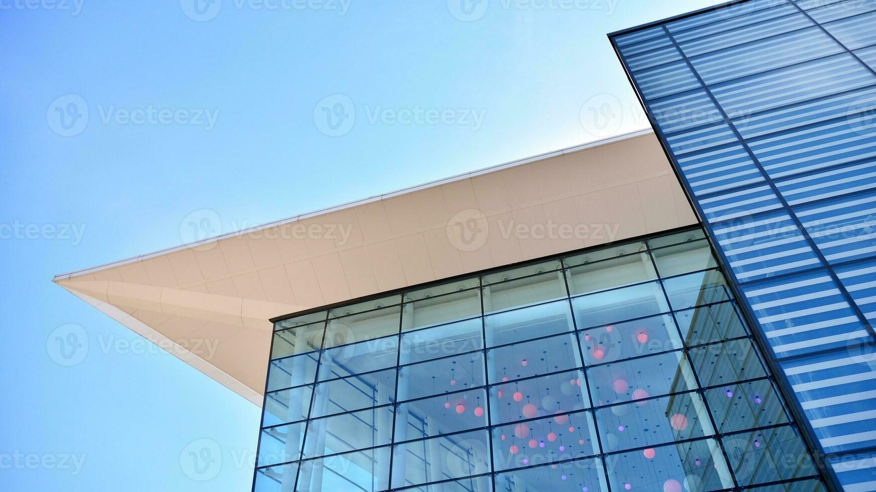 Glass building with transparent facade of the building and blue sky. Structural glass wall reflecting blue sky. Abstract modern architecture fragment. Contemporary architectural background. photo