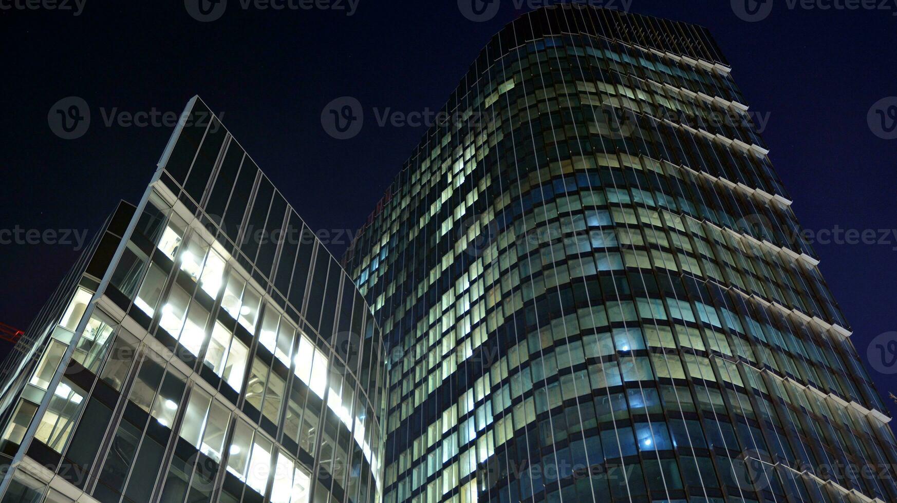 Pattern of office buildings windows illuminated at night. Glass architecture ,corporate building at night - business concept. photo