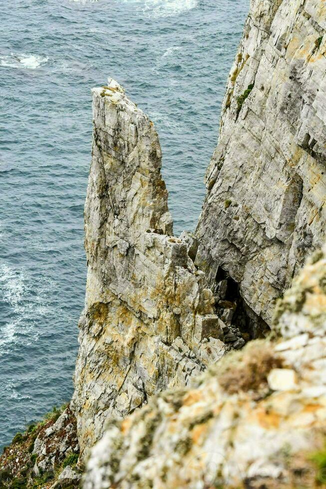 the edge of a cliff overlooking the ocean photo