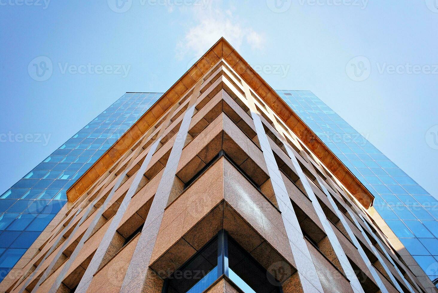 Structural glass wall reflecting blue sky. Abstract modern architecture fragment. photo