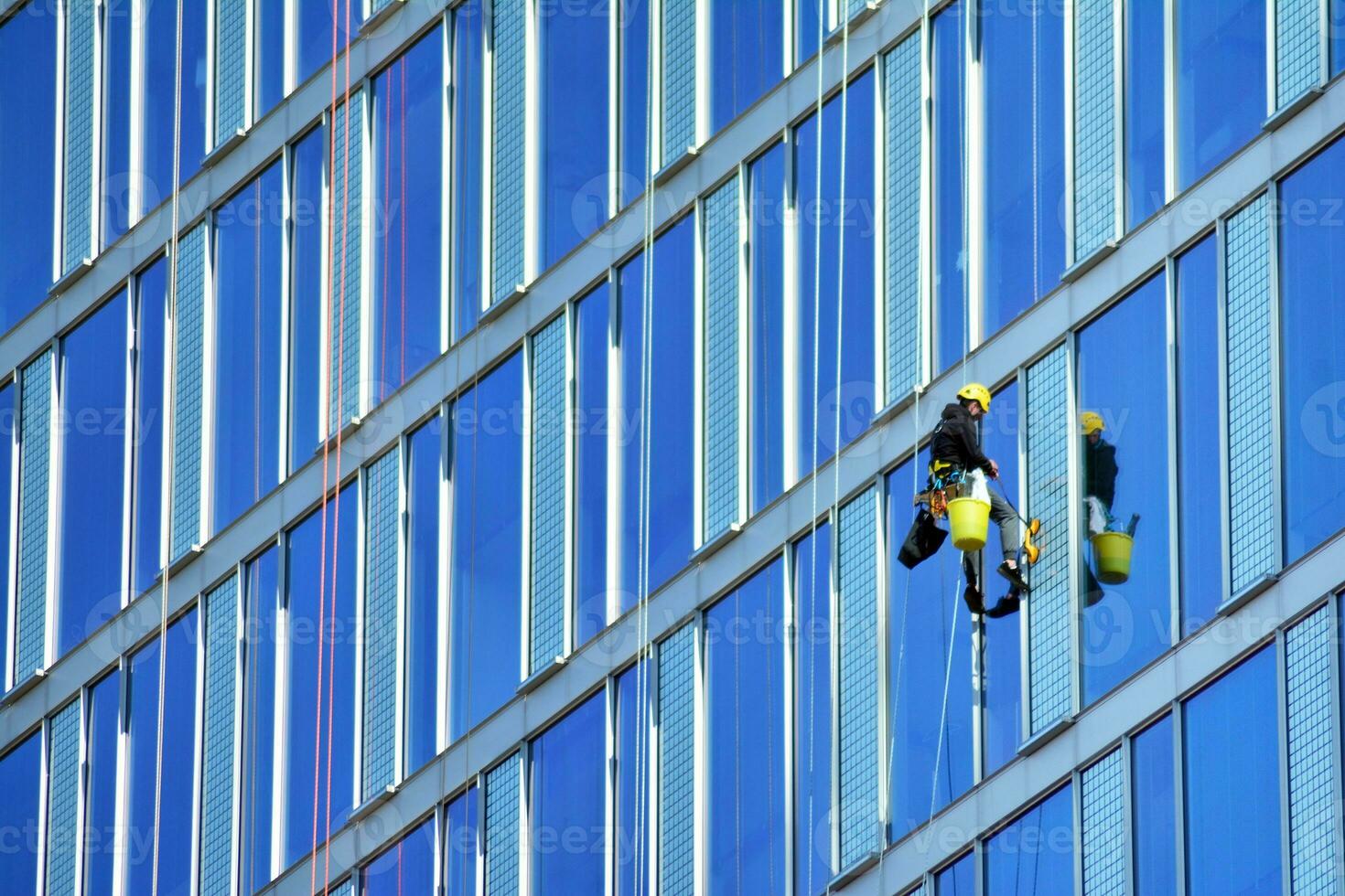 Glass building with transparent facade of the building and blue sky. Structural glass wall reflecting blue sky. Abstract modern architecture fragment. Contemporary architectural background. photo