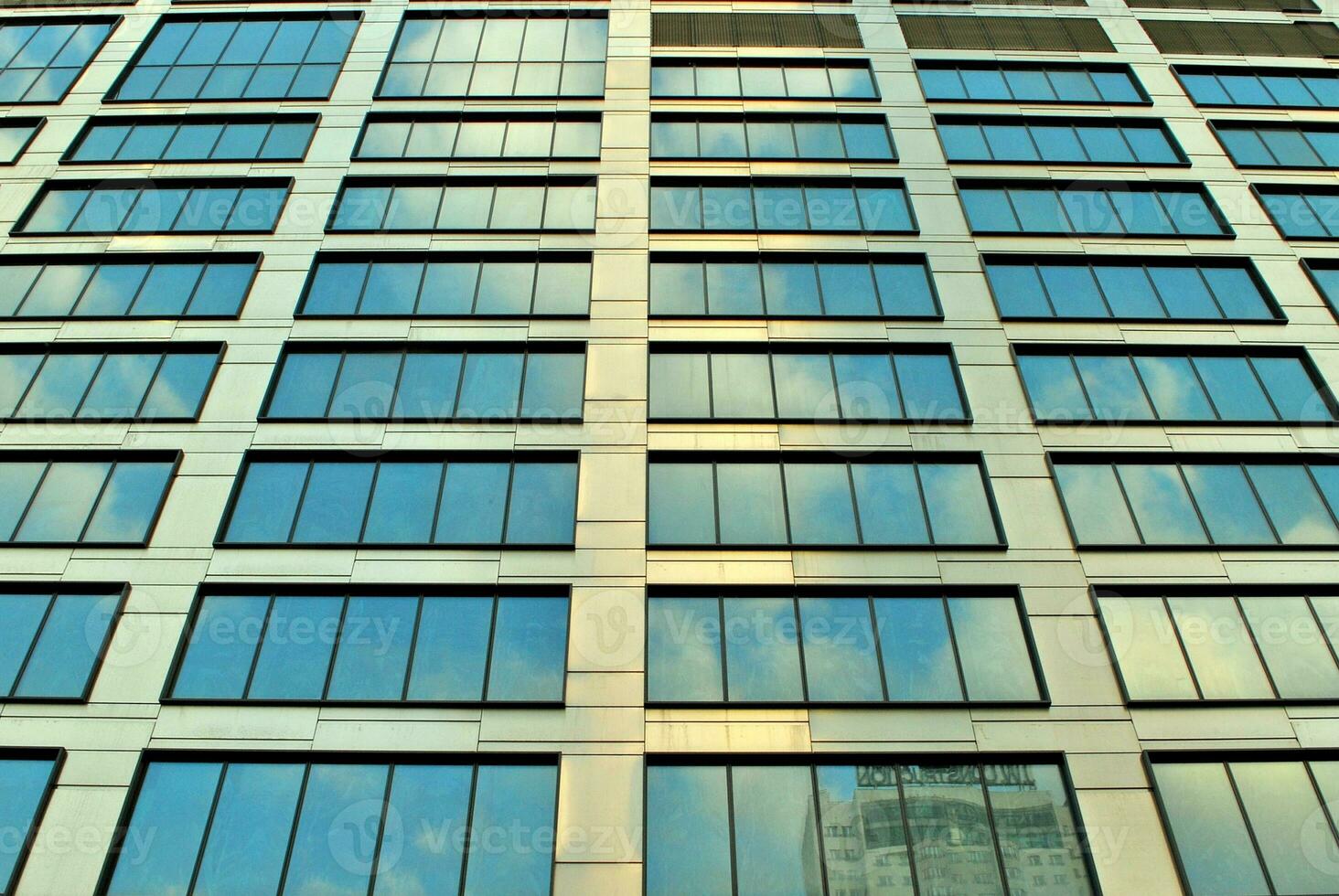 Structural glass wall reflecting blue sky. Abstract modern architecture fragment photo